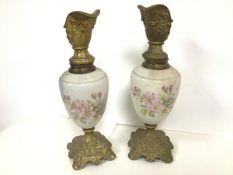 A pair of decorative ewers with gilt spouts decorated with the face of a mythical man, the opaque