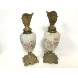 A pair of decorative ewers with gilt spouts decorated with the face of a mythical man, the opaque