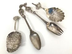 A pair of Continental chased white metal short serving spoons, one with a cherub mounted handle, the