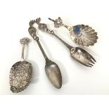 A pair of Continental chased white metal short serving spoons, one with a cherub mounted handle, the