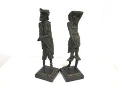 A pair of spelter Continental figure candlesticks, one modelled as a one legged man, the other, a