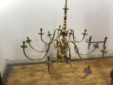 A brass pendant chandelier in the Dutch 18thc taste with eleven scrolling branches issuing from a