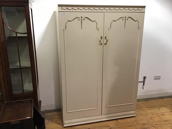 A 1950s white painted wardrobe, in the Neoclassical taste, the cornice with applied ribbon swags,