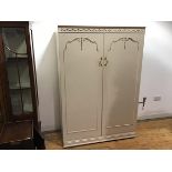 A 1950s white painted wardrobe, in the Neoclassical taste, the cornice with applied ribbon swags,