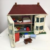 A 1960s doll's house with two metal hinged facades which open to reveal a four room home, complete