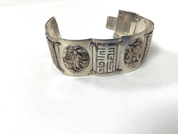 A Chinese white metal alternating figure and character panel bracelet with a snap fastening and