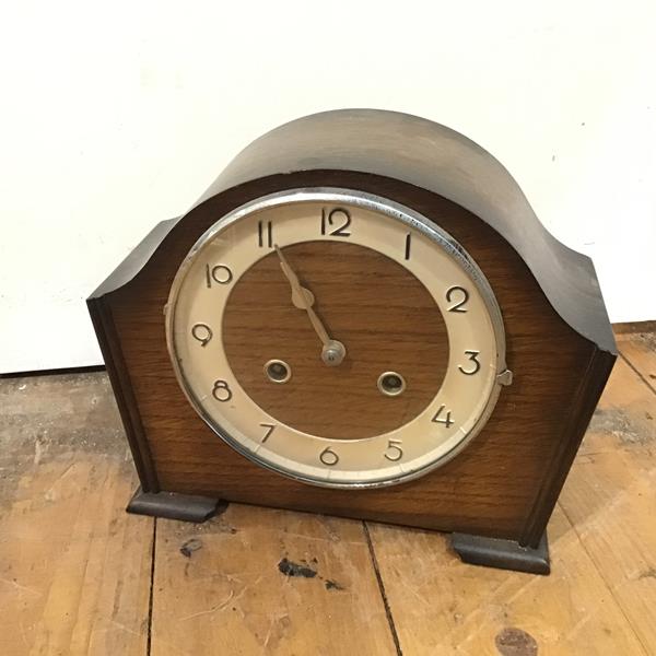 A 1930s/40s oak cased Art Deco style mantel clock with arched top over a circular dial, with