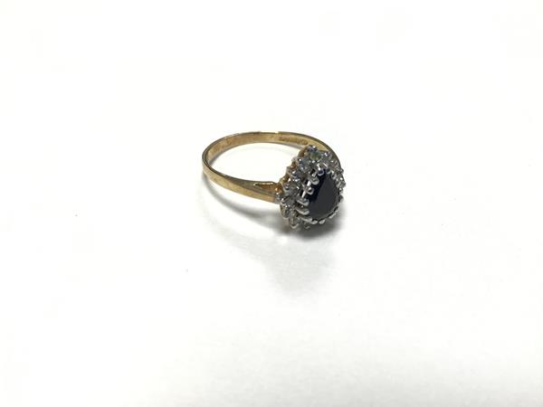 A sapphire and diamond cluster ring, the pear shaped sapphire enclosed within a surround of thirteen