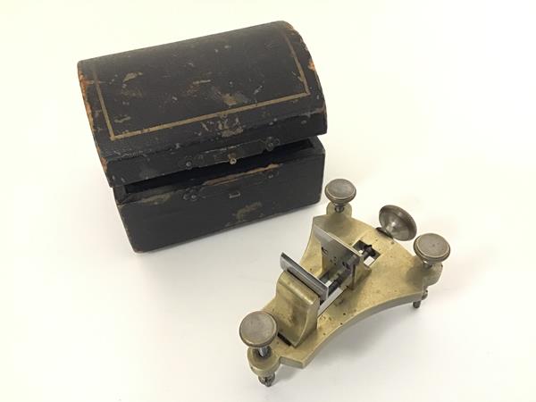 A 19thc French brass miniature watchmakers posing tool, raised on three adjustable supports,