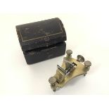 A 19thc French brass miniature watchmakers posing tool, raised on three adjustable supports,