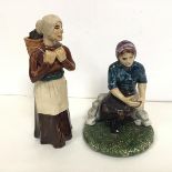 A pair of Coll Pottery figures, a Carrier Woman complete with Basket of Coal and a Woman Seated (