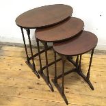A nest of three mahogany Edwardian tables, with inlaid decoration, the oval tops on turned