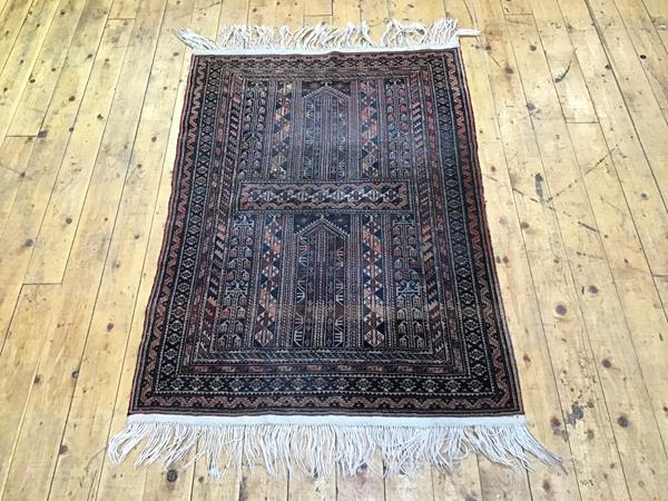 A Bokhara rug, the indigo field with two framed panels enclosed by multiple guard bands. 144cm by