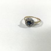 A sapphire and diamond cluster ring, the central round-cut sapphire within a band of round brilliant