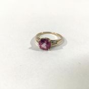 A pink tourmaline and diamond ring, the round-cut tourmaline claw-set on diamond-set shoulders, each