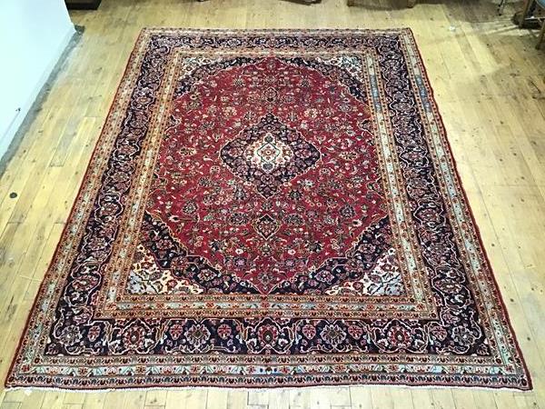 A North West Persian carpet, the red field with central ivory and blue framed medallion, within