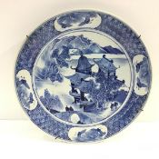 A Chinese blue and white porcelain dish, painted to the well with a pagoda within a rim with