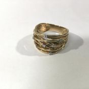 A diamond-set 9ct gold multi-band ring, the fixed interlocking bands claw-set with seven round