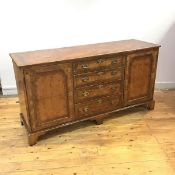 A George II style walnut and burr walnut side cabinet, the rectangular top with inverted corners,