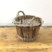 A Hebridean woven willow herring basket, of tapering form, with raised carrying handles and panel