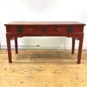 A Chinese red lacquer side table, the rectangular top over three frieze drawers, each with