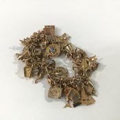 A 9ct gold fancy link charm bracelet, suspending a large quantity of charms, the majority 9ct with