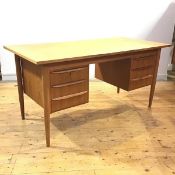 A Danish teak desk, the rectangular top above two banks of three drawers, arranged around a