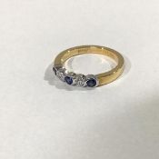 A five stone sapphire and diamond ring, the three round-cut collet-set sapphires spaced by a pair of