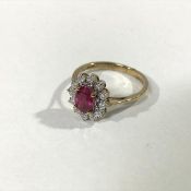 A ruby and diamond cluster ring, the oval-cut ruby claw-set within a band of twelve round