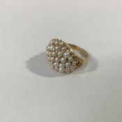 A cultured pearl cluster ring, the domed plaque set with multiple small pearls on a tapering