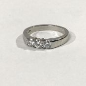 A platinum three stone diamond ring, the uniform round brilliant-cut stones set on a tapering band