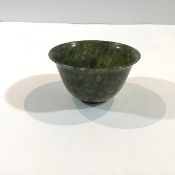 A Chinese spinach-green jade bowl, the plain body with gently flaring rim, on a ring foot, the