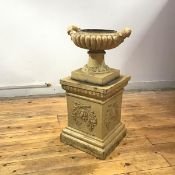 A Victorian glazed fireclay urn, the gadrooned body with raised handles and socle base, on a