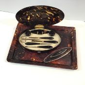 An Edwardian silver-gilt mounted tortoiseshell manicure set, London 1908, oval, the hinge with