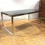 A modern dining table, 1980's, the rectangular smoked glass top raised on a chrome plated steel