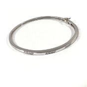 A diamond-set 18ct white gold bangle, the hinged tapering band set to one half with five lines