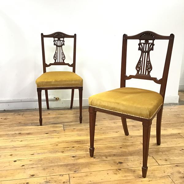 A pair of late 19th century oak side chairs in the Neoclassical taste, each arched top rail