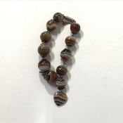 A late 19th century banded agate bead bracelet, of uniform spherical beads, mounted in white metal