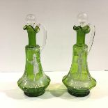 A pair of Mary Gregory style green glass ewers, with characteristic decoration in white enamel,