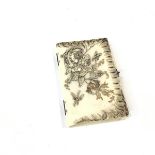 A carved ivory notecase, c. 1900, of book form, the cover in relief with dragonflies and a floral