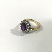 An 18ct gold amethyst and diamond cluster ring, the oval-cut amethyst claw-set within a band of