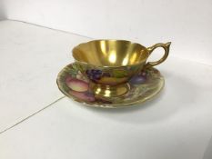 A mid 20thc Aynsley china teacup and saucer with gilt interior, handle and edges, and fruit