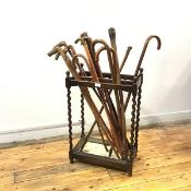 A 1930s oak stick stand, the rectangular top with six divisions and turned finials, raised on barley