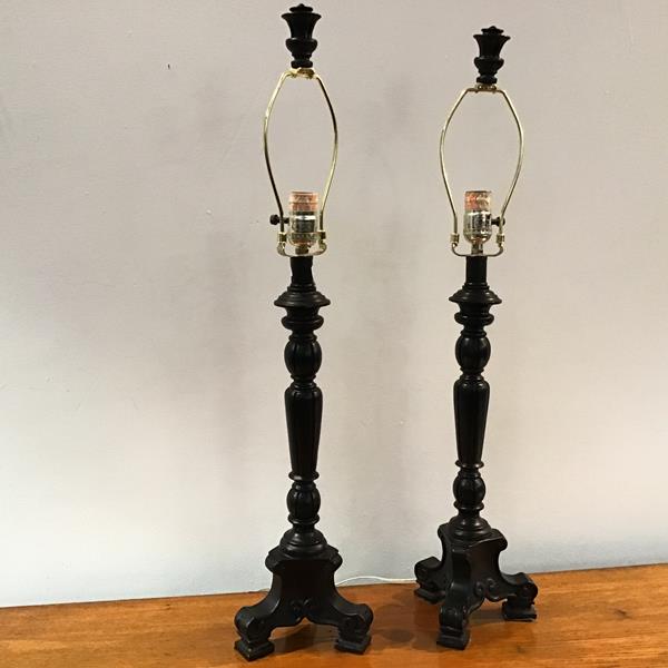 A pair of ebonised table lamps of baluster form, on a tripod base, with matching finial to top of