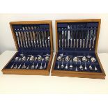 A pair of cutlery canteens containing dinner knives, soup spoons, teaspoons, serving spoons,