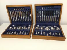 A pair of cutlery canteens containing dinner knives, soup spoons, teaspoons, serving spoons,