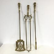 A set of brass fire tools, including a pierced shovel, tongs and poker (l. 67cm)