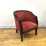 An ebonised tub chair, the hoop shaped frame enclosing a padded back and seat, on shaped tapering