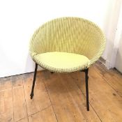 A 1950s woven cane chair, the hoop shaped back enclosing a corresponding seat on ebonised steel
