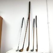 A collection of golf clubs from various periods, including a wood marked Cruden Bay, a wood with